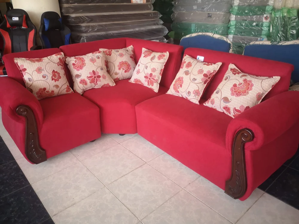 Sofá esquinero rojo con cojines florales en nuestra tienda